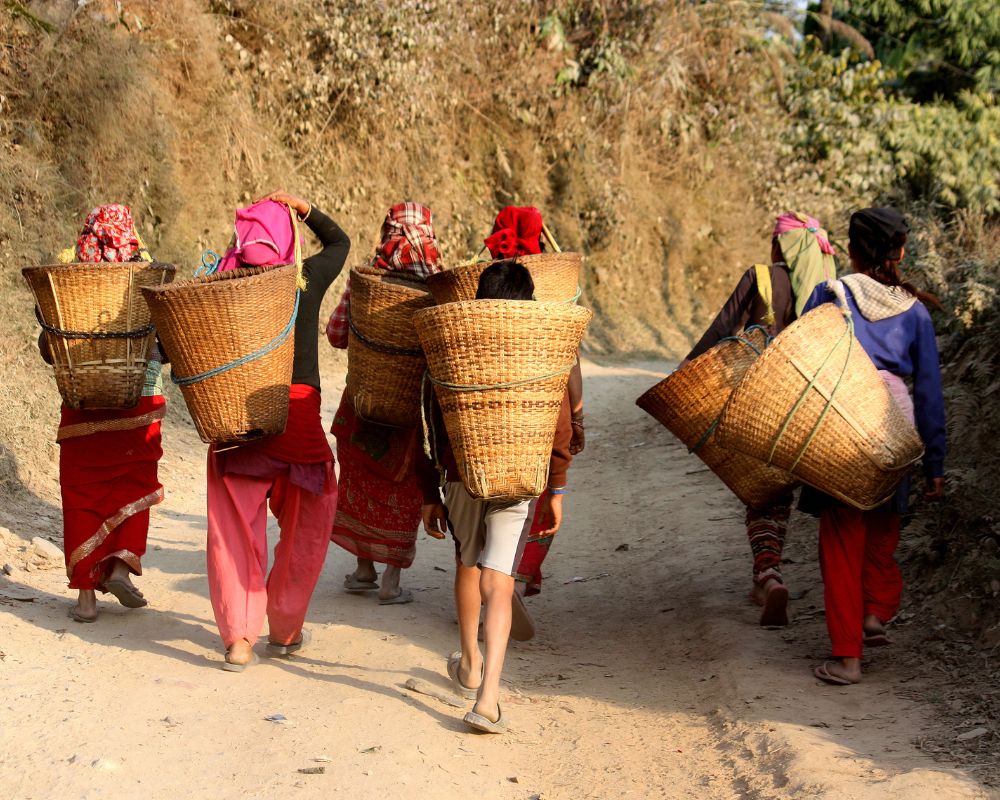 Hmong-people-carrying-baskets-on-the-dirt-road